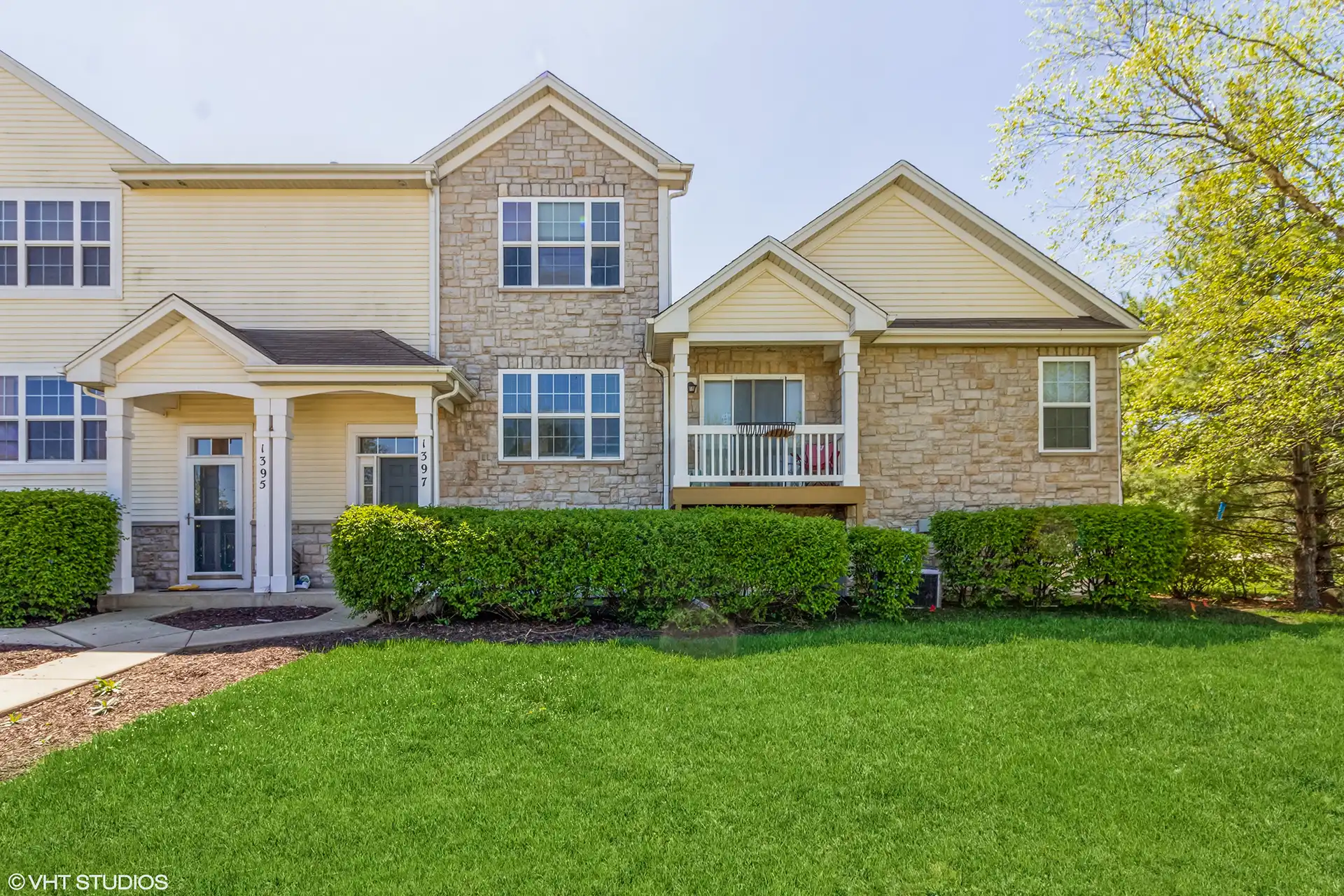 row of townhomes with yellow wood and light brown stone siding.